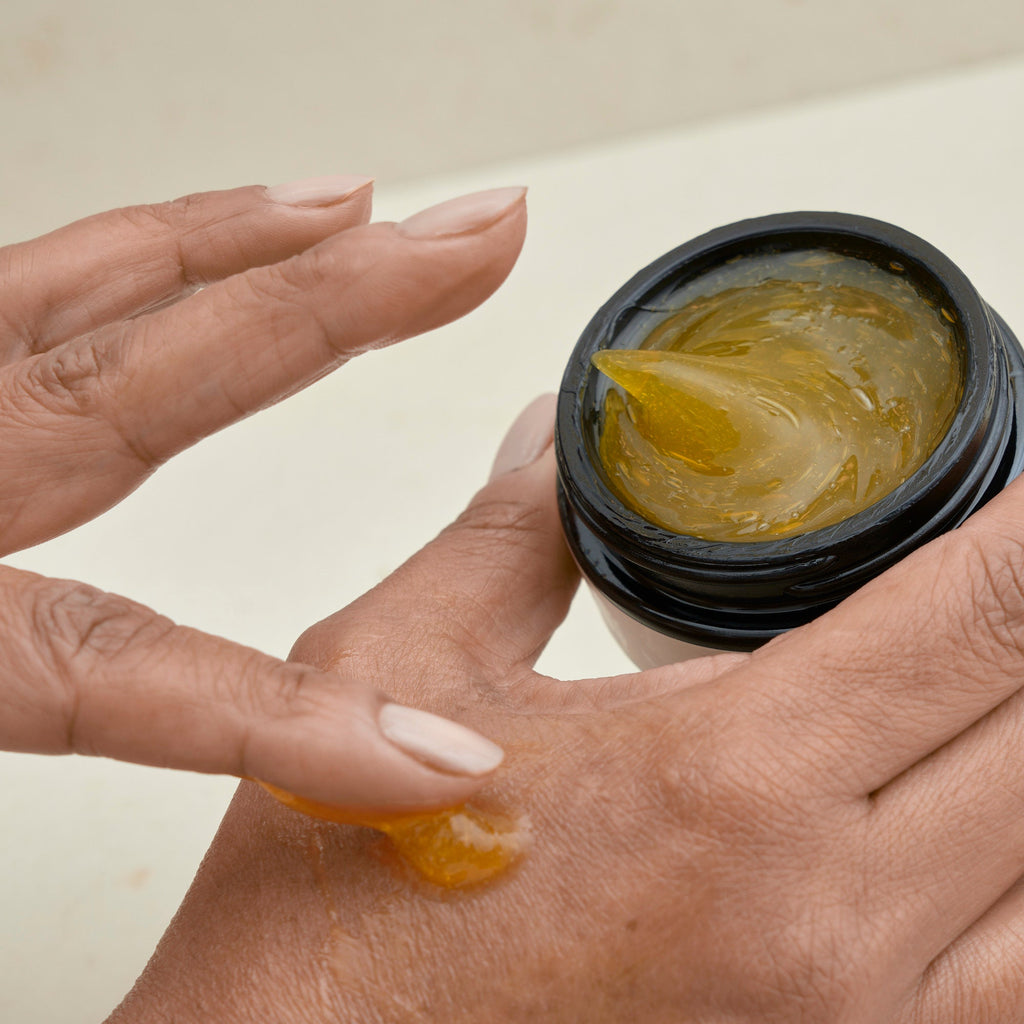 rubbing cleansing jelly from pot into hand  