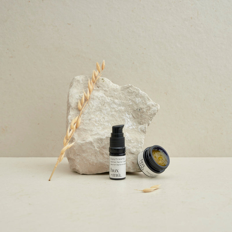 hux and mu mini mu signature ritual facial cleansing kit in neutral setting with stone and dried foliage